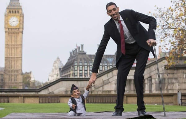 Chandra Bahadur Dangi, from Nepal, (L) the shortest adult to have ever been verified by Guinness World Records, poses for pictures with the world's tallest man Sultan Kosen from Turkey, during a photocall in London on November 13, 2014, to mark Guinness World Records Day. Chandra Dangi, measures a tiny 21.5in (0.54m)  the same height as six stacked cans of beans. Sultan Kosen measures 8 ft 3in (2.51m).  AFP PHOTO / ANDREW COWIEANDREW COWIE/AFP/Getty Images