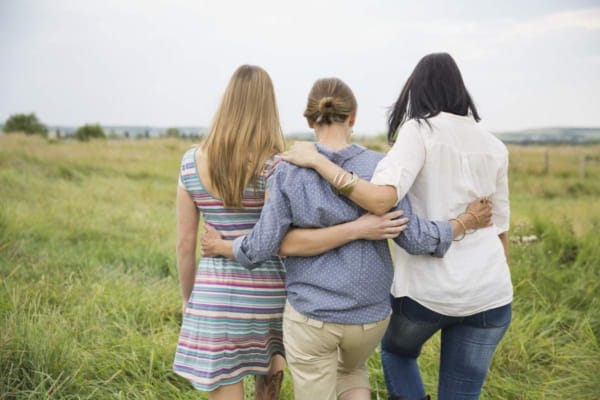 Rear view of female family members walking through field